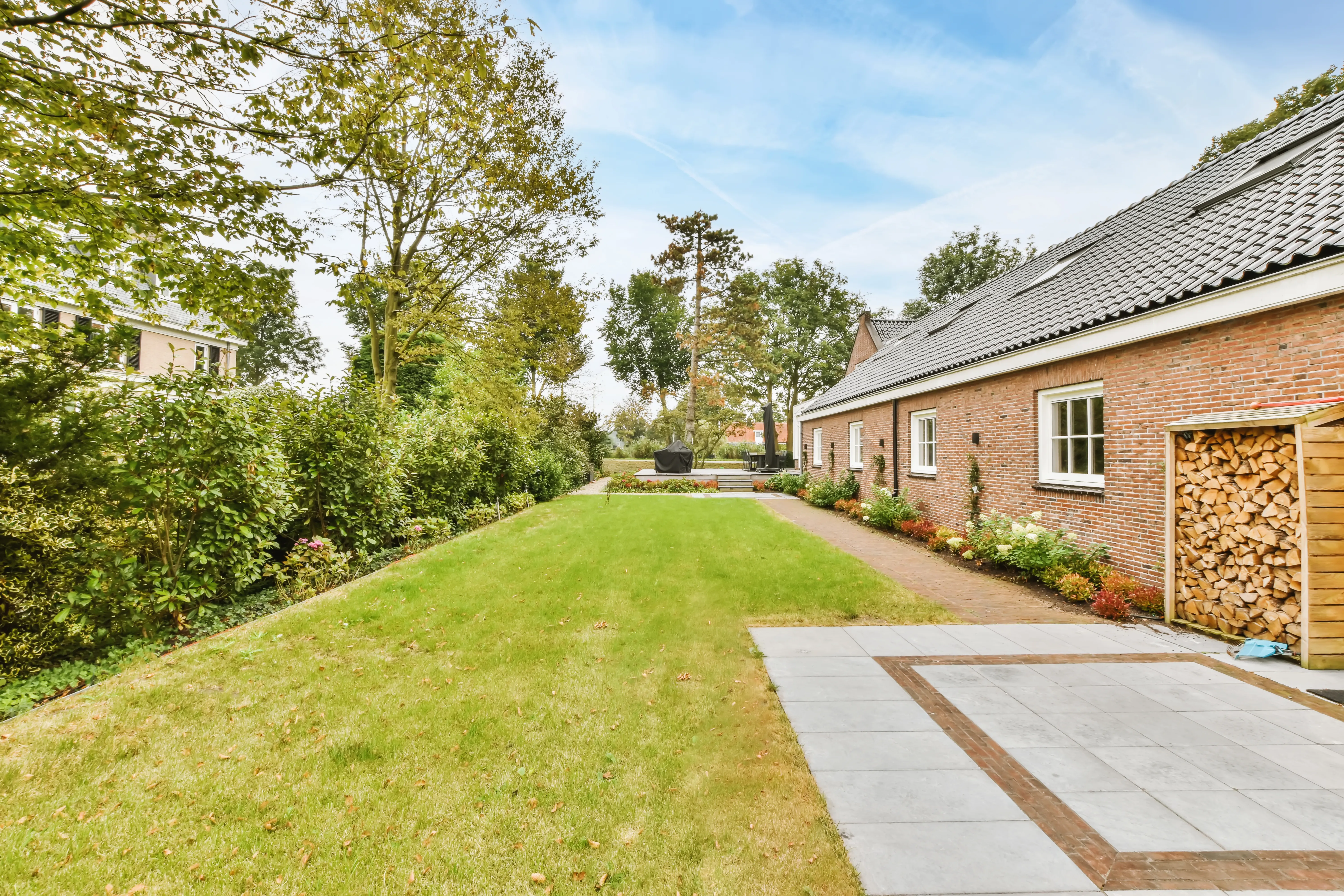 The facade of a one-story brick house with a green lawn.