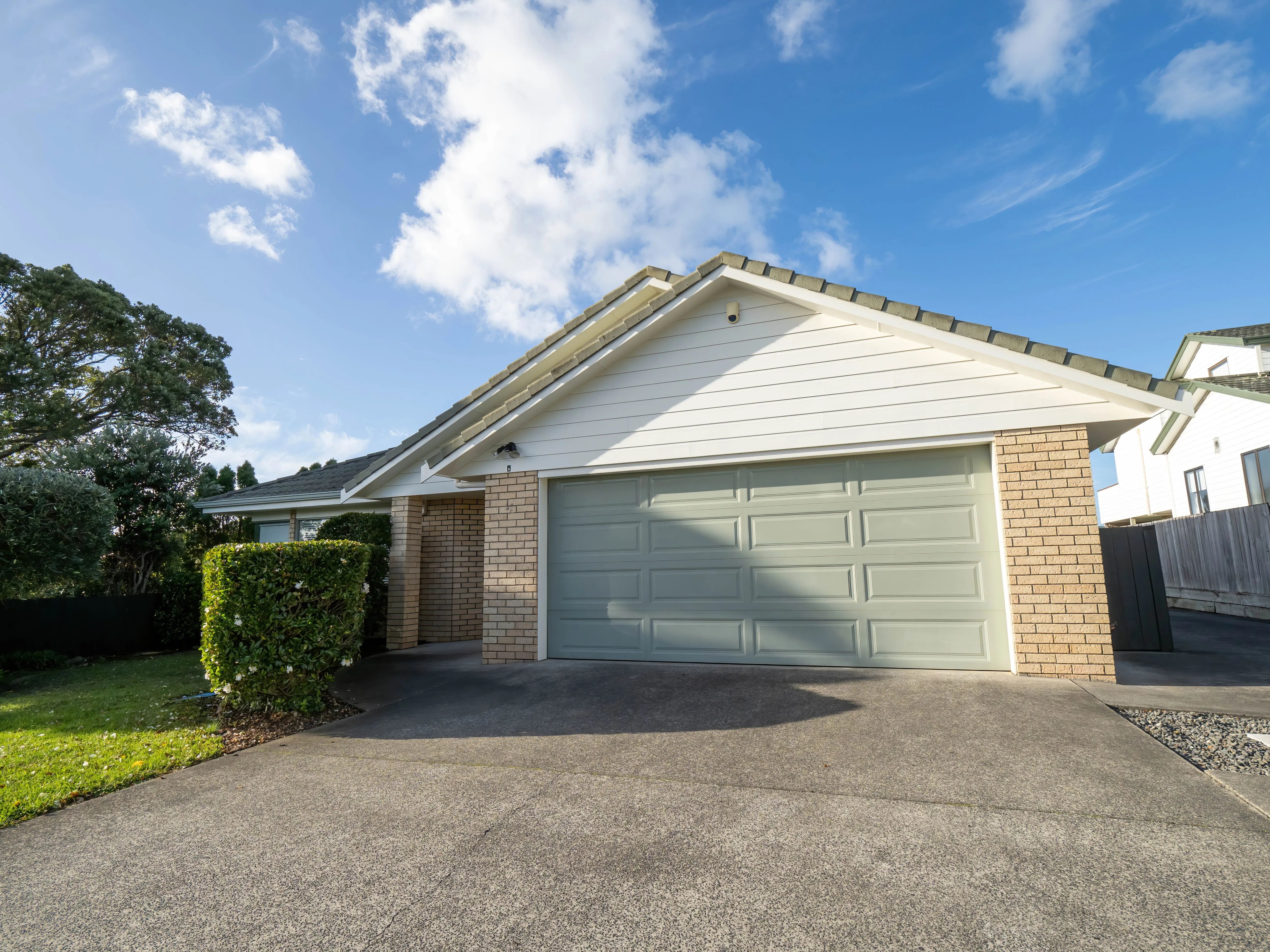 A suburban house with a roller garage door under a gabled roof.