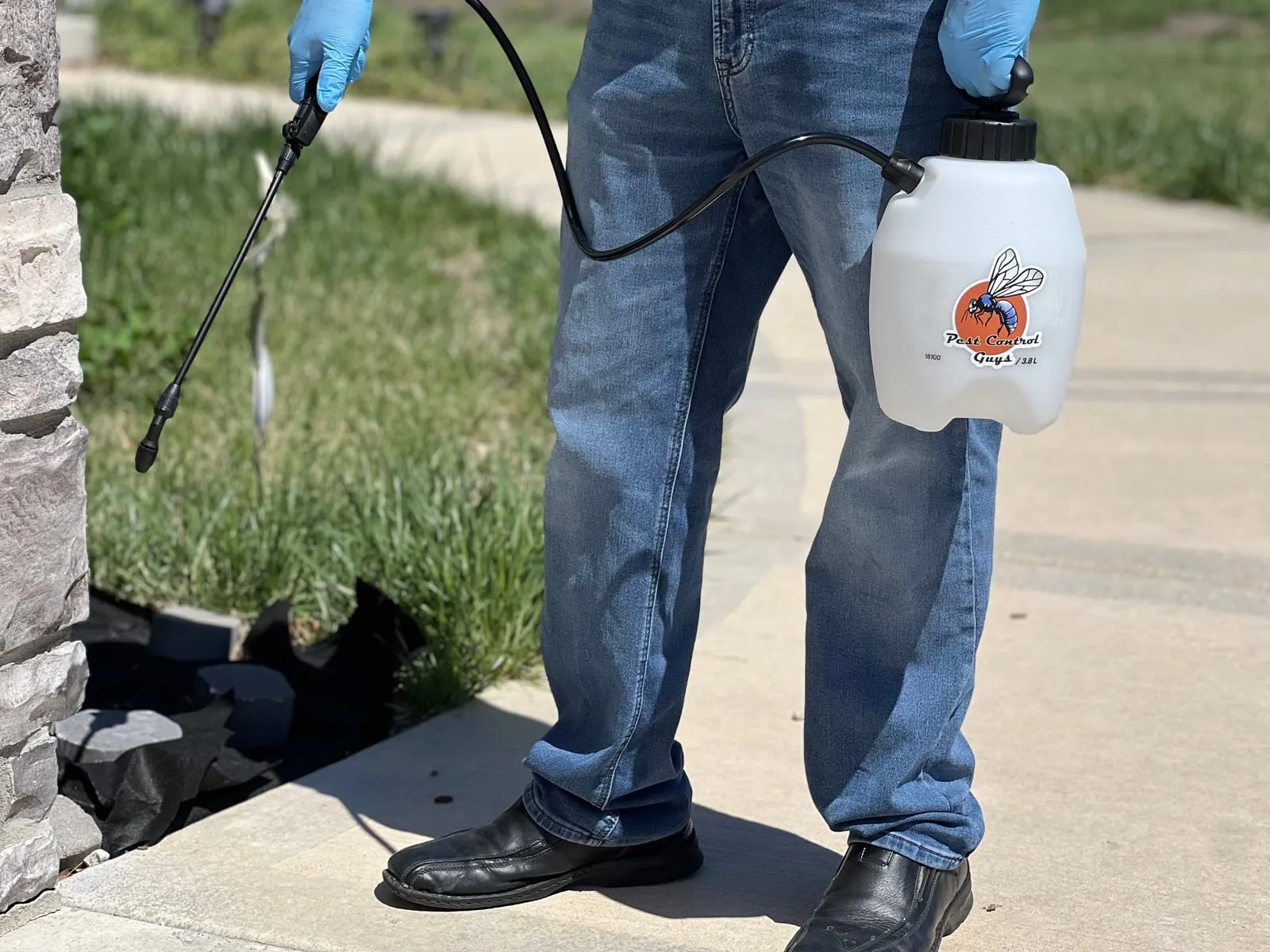 Spraying a treatment barrier along the foundation and entryway of a home.